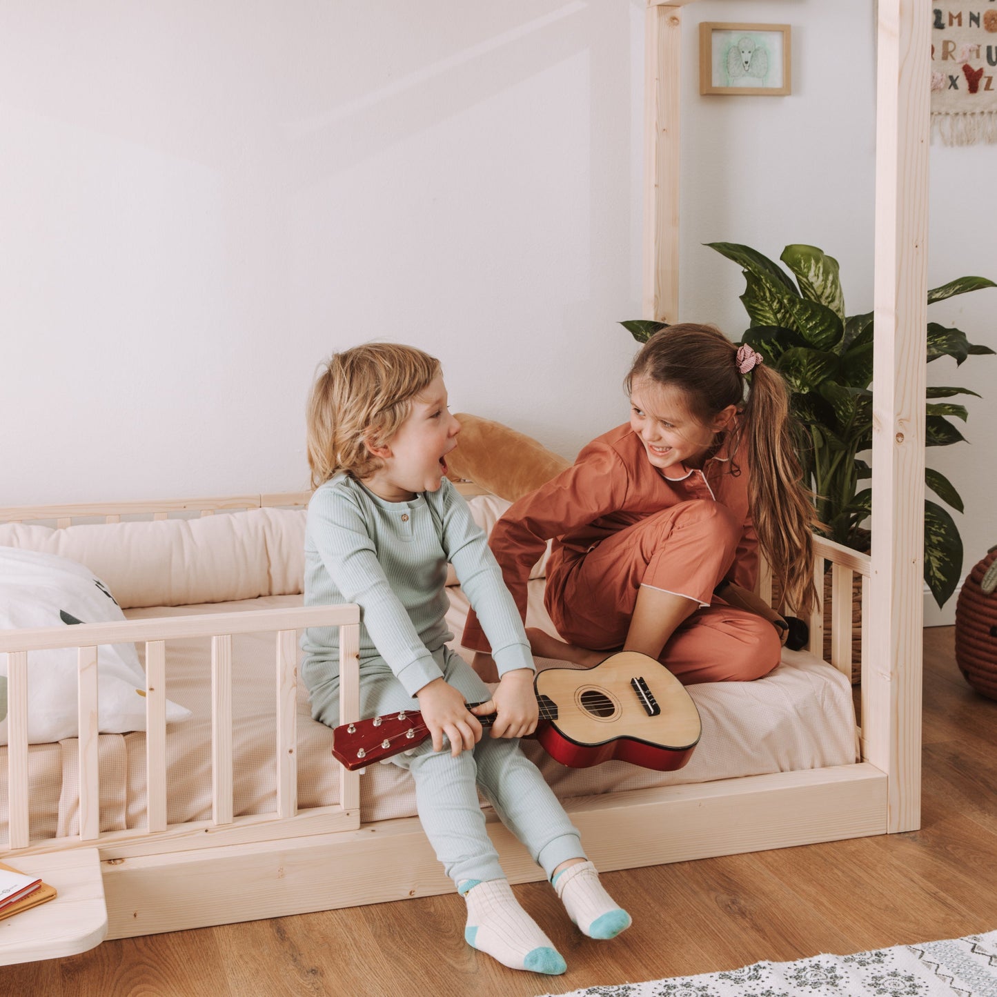 bambini giocano seduti su letto montessoriano in legno naturale zero+ dream