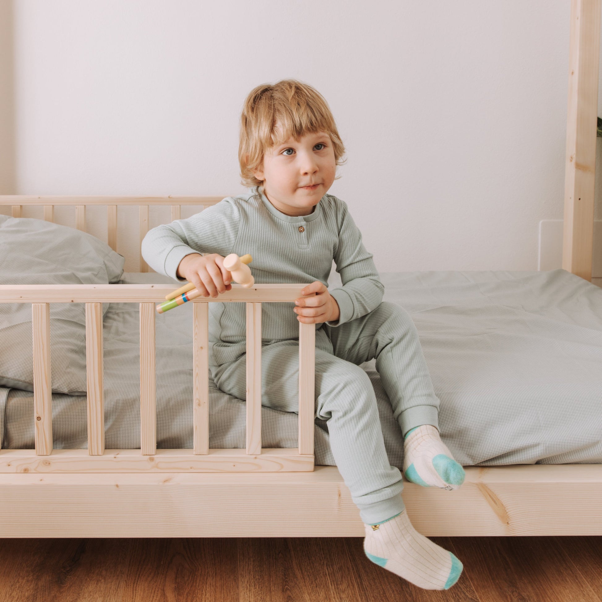 bambino seduto su lettino montessoriano nabè in legno