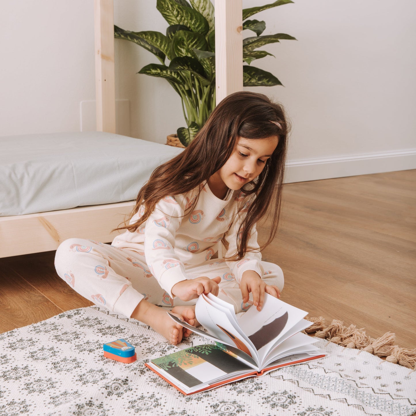 bambina di seduta vicino a letto montessori in legno zero+ dream