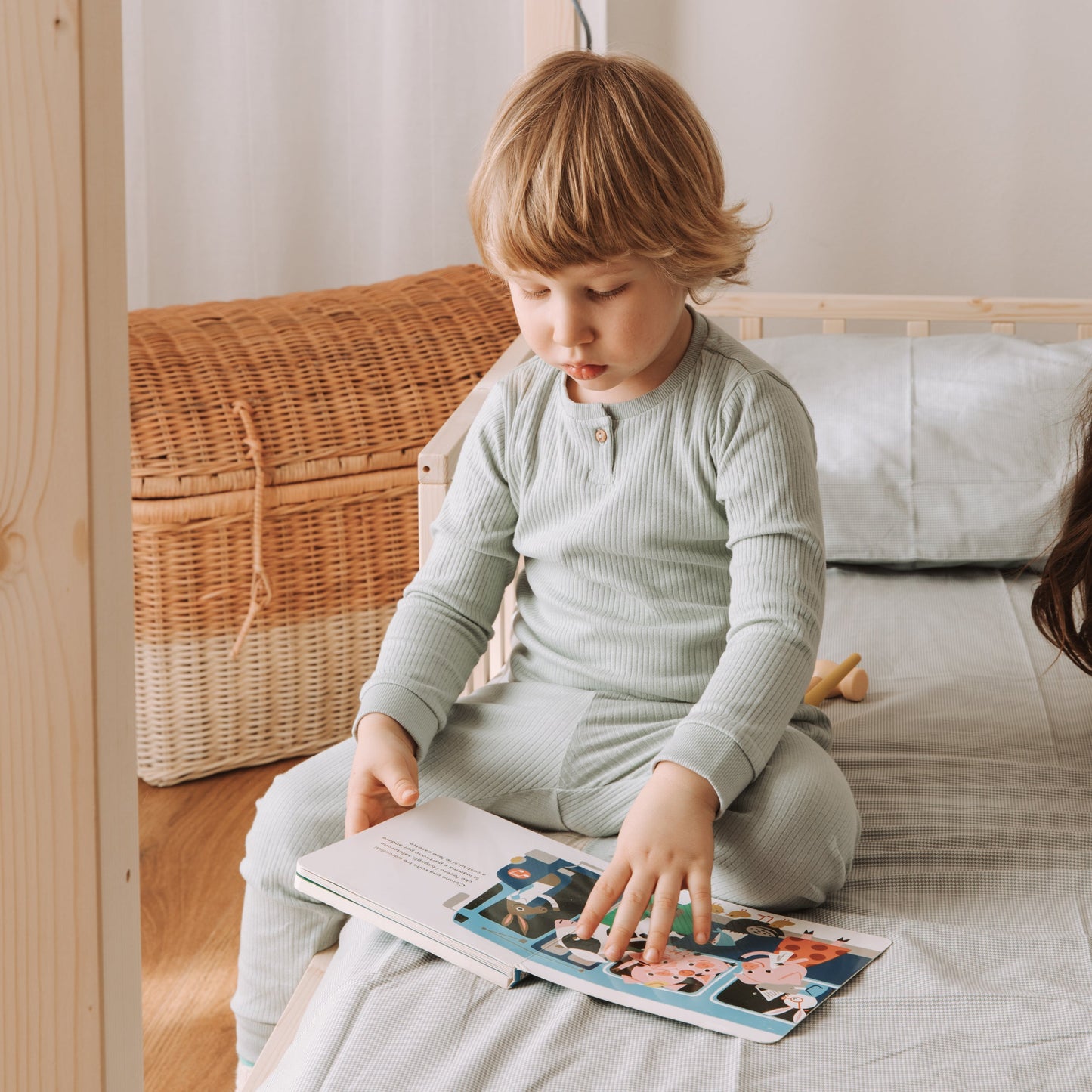 bambino legge un libro su un lettino montessoriano zero+ nabè dream