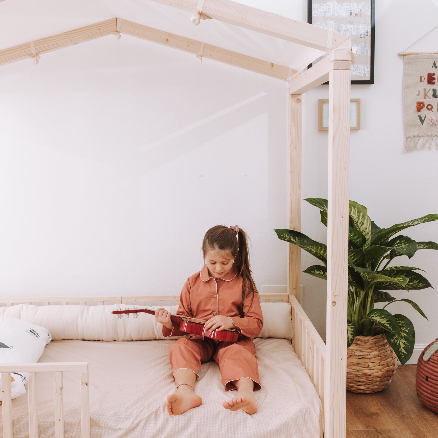 bambina seduta su letto zero+ dream con cuscino paracolpi in cotone naturale