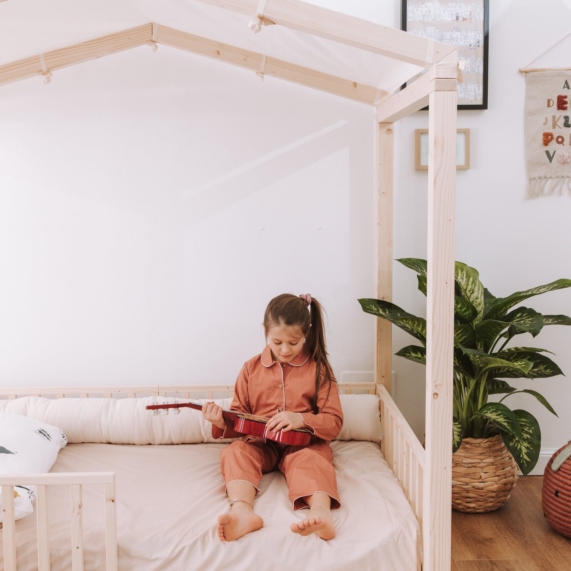 bambina seduta su letto zero+ dream con cuscino paracolpi in cotone naturale