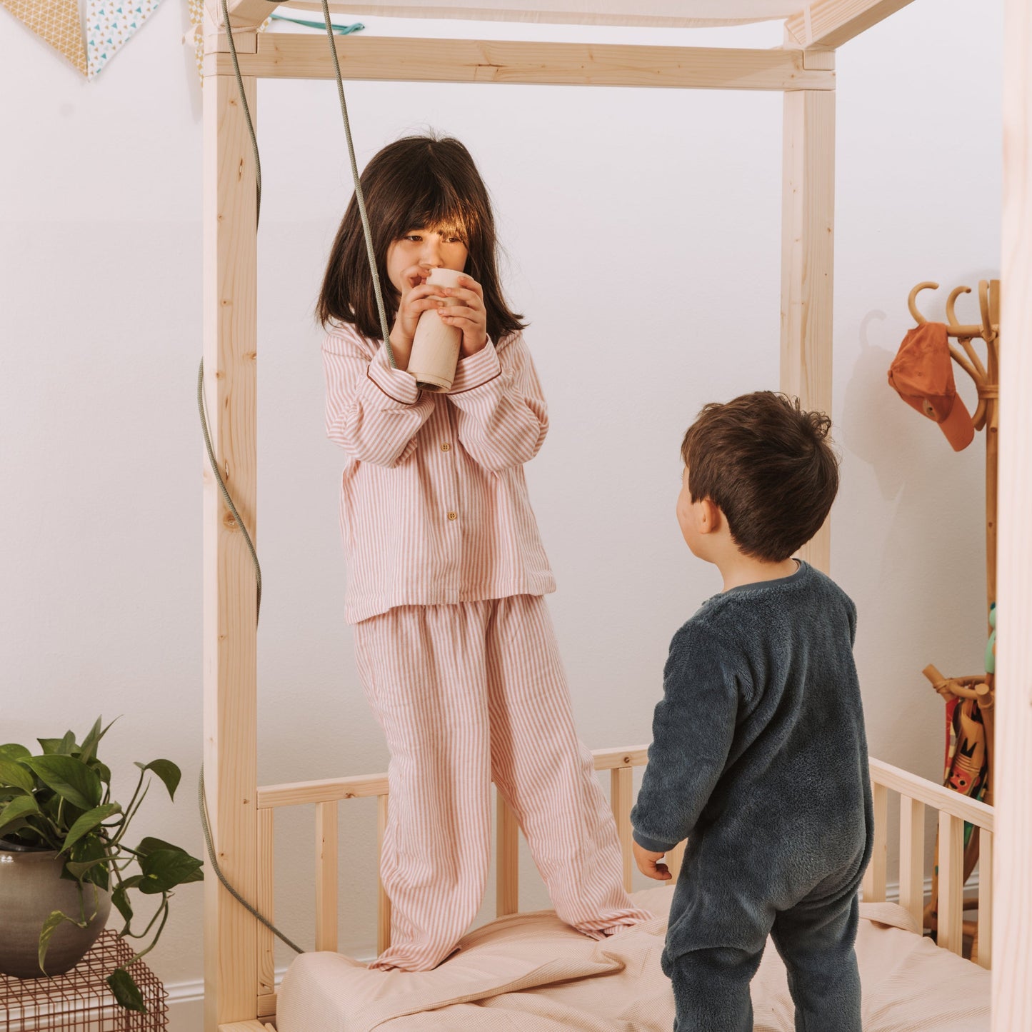 bambini giocano su letto per bambini in legno naturale massello con baldacchino e barriere