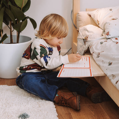 bambino disegna su comodino nabè per letto montessori in legno naturale