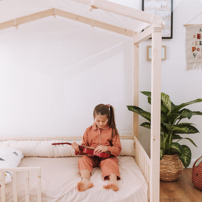 bambina seduta su letto zero+ dream con cuscino paracolpi in cotone naturale 