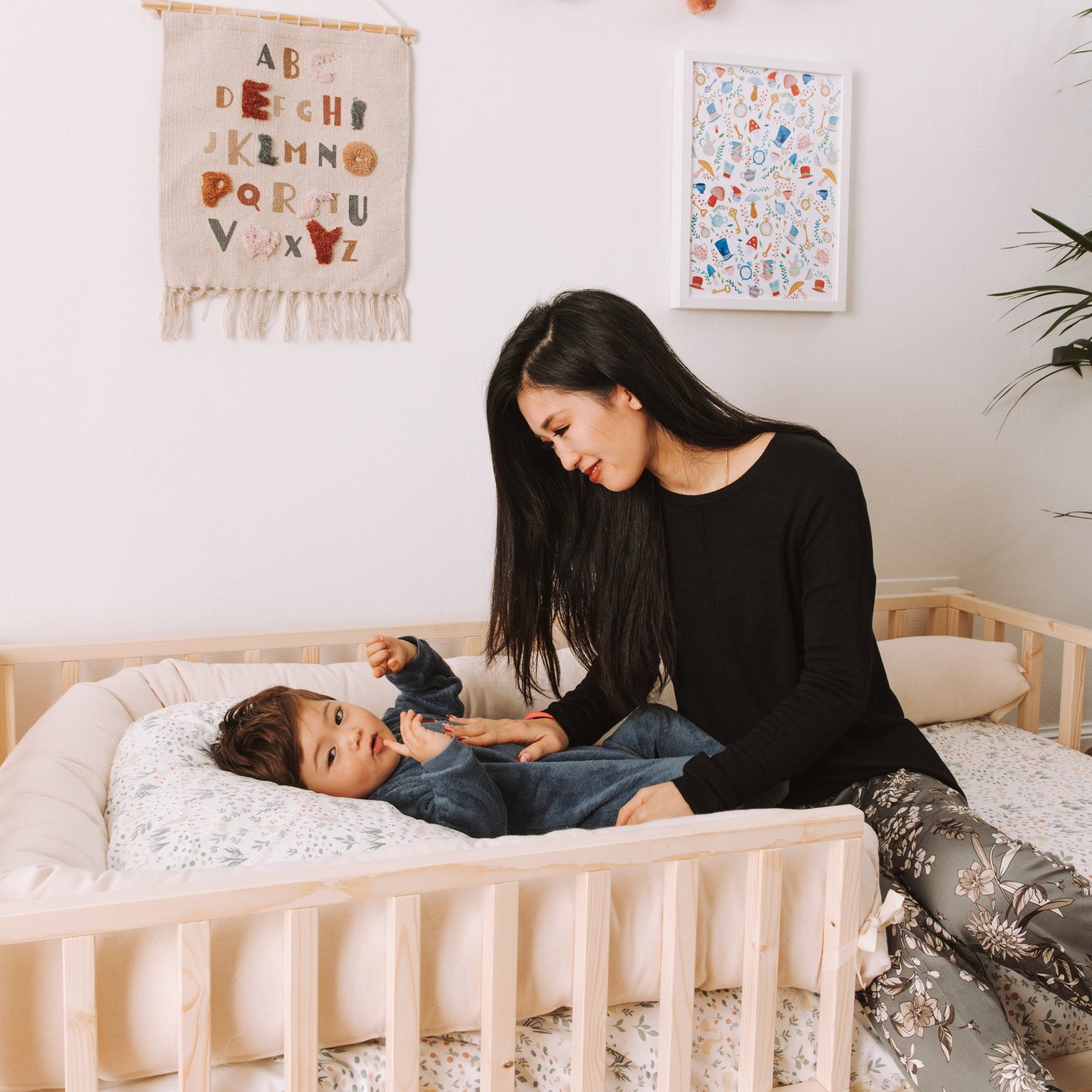 mamma e bambino su letto montessoriano zero+ dream con barriere e cuscino paracolpi