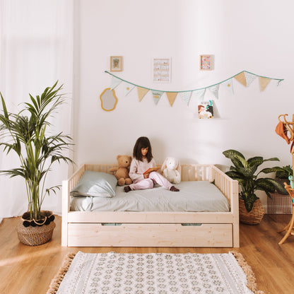 bambina legge sul suo letto montessoriano zero+ earth con cassettone estraibile